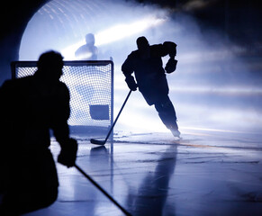 A silhouette of an ice hockey player skating out from a player entrance with smoke and light rays pouring out it.