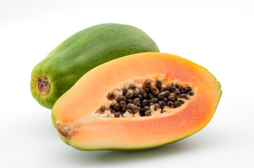Vitamin rich exotic fruits concept with photograph of whole papaya and halved fruit isolated on black background with clipping path cutout