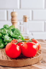 Olive oil, tomato and basil on rustic wooden table. Italian cuisine concept. Ready for cook