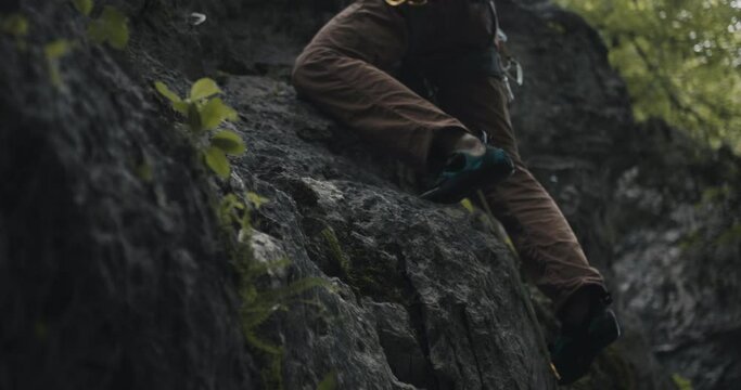 Climber ascend climb up high reach hand in chalk bag and attach clip lead rope in quickdraw carabiner