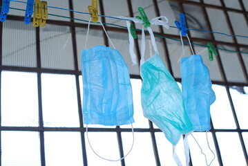 Blue disposable surgical mask washed and hanging on a drying rack. Concept of shortage of personal...