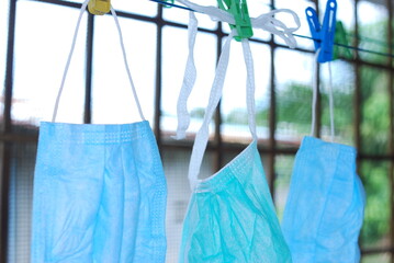 Blue disposable surgical mask washed and hanging on a drying rack. Concept of shortage of personal...