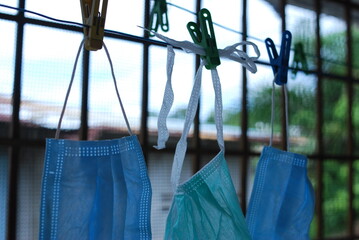 Blue disposable surgical mask washed and hanging on a drying rack. Concept of shortage of personal...