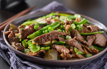 chinese beef and snowpeas stirfry on plate