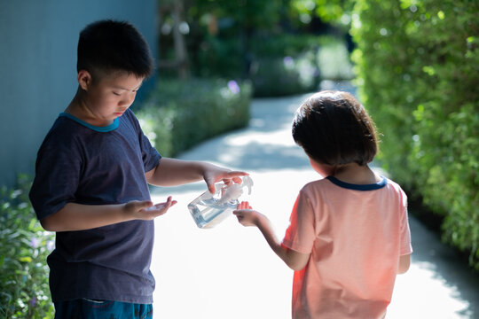 The boy pressed the gel to wash hands for his sister
