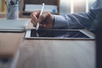 Obraz premium Businessman using stylus pen on digital tablet working in office