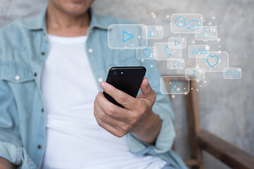 man using mobile phone with social media technology icons on virtual screen