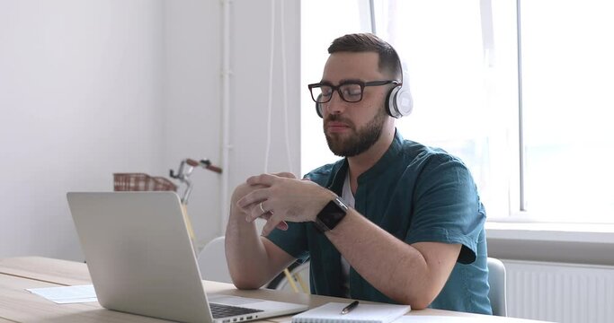 Businessman wear wireless headphones making video conference business call on laptop speaking communicating by webcam, male teacher manager talking do online chat on computer sit at home office desk