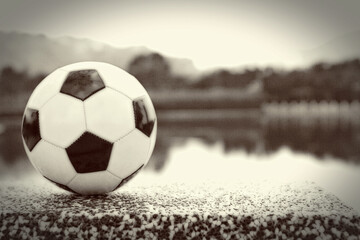 Fototapeta na wymiar Soccer ball by the lake
