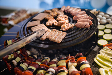 The chef grills meat and vegetables in the backyard