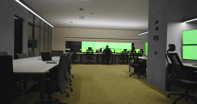 Empty office, desk, and chairs at a main CCTV security data center with green screen and chroma key