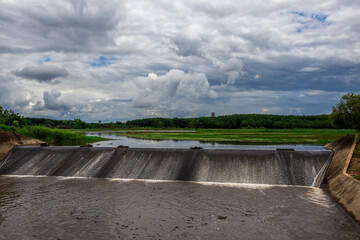 The natural background of green rice paddies and large trees surrounded by cool breezes, seen in...