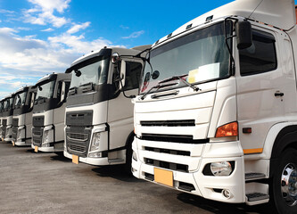 Semi truck parked lined up at a blue sky, Road freight cargo industry delivery service, Logistics and transportation.