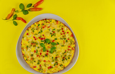 Omelette with fork and knife on yellow background.
