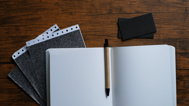 notebook and pen on wooden background