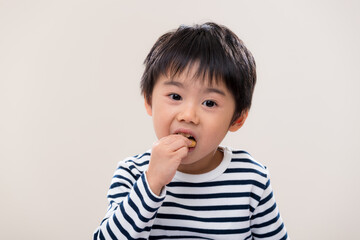 Kid boy eat cookie on white background