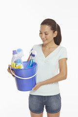 Woman holding a bucket filled with cleaning supplies