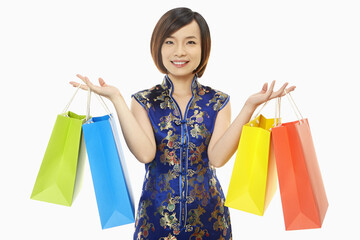 Cheerful woman in traditional clothing carrying paper bags