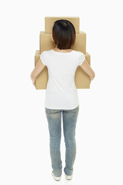 Woman carrying a stack of cardboard boxes