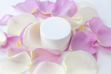 Natural organic homemade cosmetics concept. Skin care (therapy), beauty products: containers with cream among delicate rose flowers petals on white background. Flat lay, top view mock up