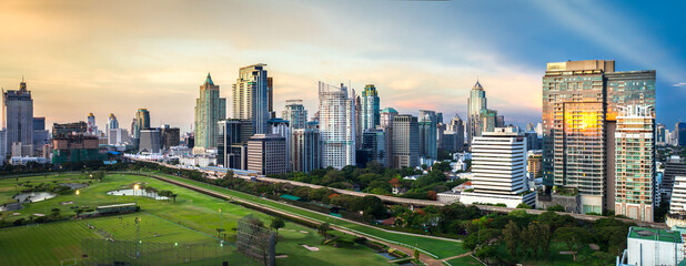 Fototapeta premium Panorama of Bangkok City, Business district with Football Field at dusk