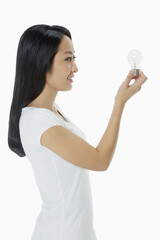 Woman holding up a light bulb