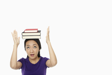 Woman balancing a stack of books on her head