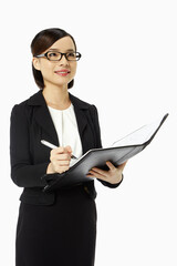 Businesswoman writing notes in folder