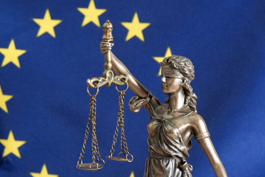 Flagge der EU und Justizia Statue