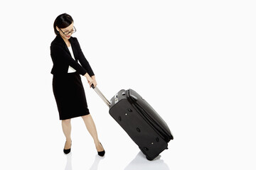 Businesswoman pulling a heavy luggage bag