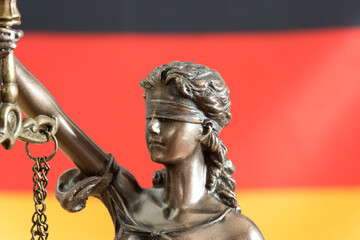 Statue der Justitia und Flagge von Deutschland