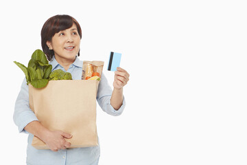 Woman with groceries holding up a credit card