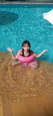 Asian cute child girl Swimming in the pool smiling happy