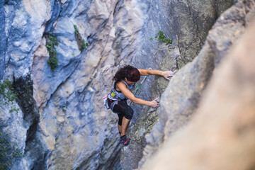 Naklejka na ściany i meble A woman is climbing in Turkey, Turkish woman climbs the rock.