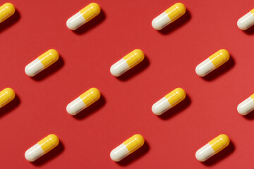 medicine, healthcare and pharmacy concept - white and yellow pills or capsules lie in rows diagonal...