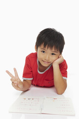 Boy lying on his front, showing a Peace sign