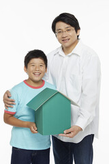 Obraz premium Father and son holding a cardboard house