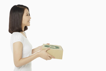 Cheerful woman carrying a recyclable cardboard box