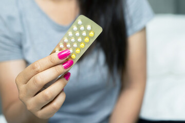 Woman is holding birth control pills to prevent pregnancy