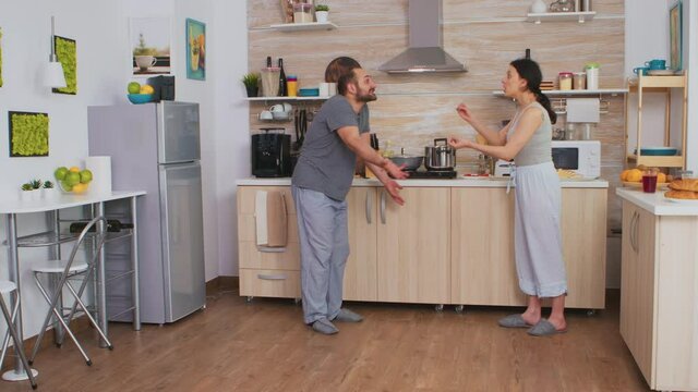Angry wife smashing dish in an argument with husband. Frustrated upset unhappy married woman swearing, smashing dishes, making scandal. Spouse arguing with passion, disagreement conflict and