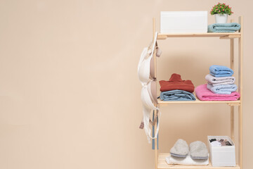Wardrobe rack with clothes and storage box on the shelves on light background with copy space.