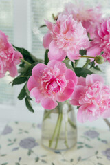 Pink peonies in vase on the table. country still life