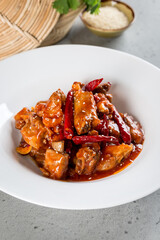 Fried pork ribs in pepper sauce in a white plate