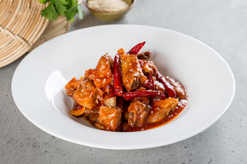 Fried pork ribs in pepper sauce in a white plate