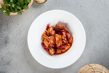 Fried pork ribs in pepper sauce in a white plate