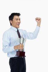 Businessman holding a trophy and cheering