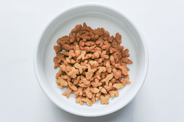 白バックでトップビューの白い陶器に入れた茶色いキャットフード