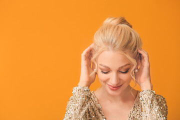 Beautiful young woman with stylish hairdo on color background