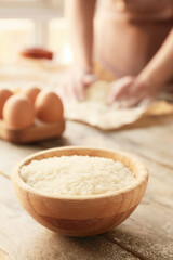 Bowl with raw rice on table