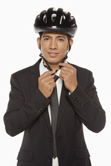 Businessman putting on a bicycle helmet